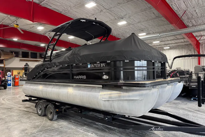 Slide: The Image of 2022 Harris Sunliner 230 pontoon boat with cover on trailer in indoor showroom. - 16