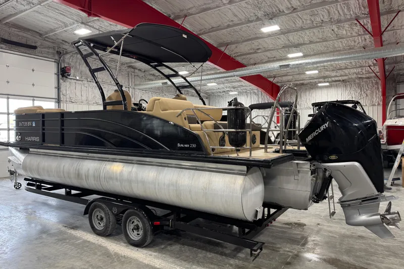 Slide: The Image of 2022 Harris Sunliner 230 pontoon boat with Mercury engine in a warehouse setting. - 3