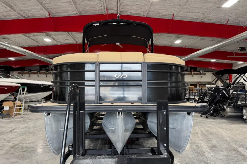 Slide: The Image of 2022 Harris Sunliner 230 pontoon boat in a showroom with red ceiling beams. - 6