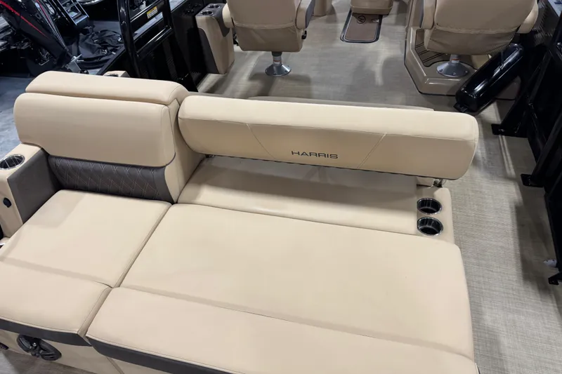 Slide: The Image of 2022 Harris Sunliner 230 boat interior with beige seating and cup holders. - 8