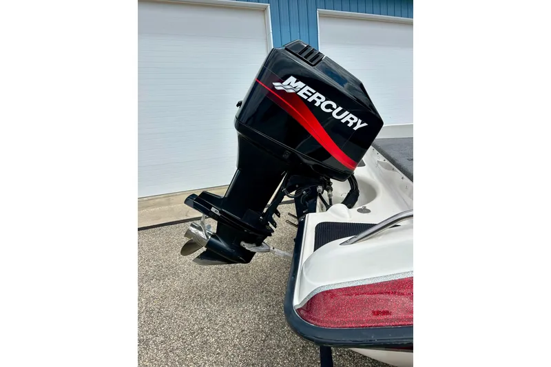 Slide: The Image of 1994 Stratos 290 Ski-N-Fish boat with Mercury outboard motor, parked outdoors. - 10