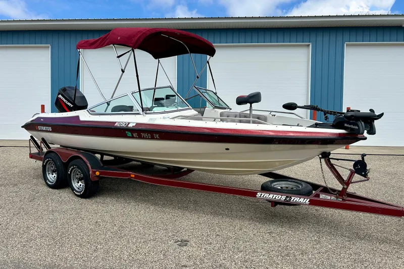Slide: The Image of 1994 Stratos 290 Ski-N-Fish boat on trailer, red and white, parked outdoors. - 2