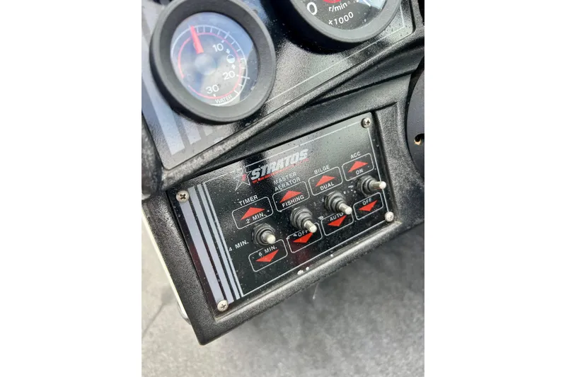 Slide: The Image of Control panel of a 1994 Stratos 290 Ski-N-Fish boat with switches and gauges. - 38