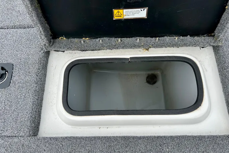 Slide: The Image of Open storage compartment in 1994 Stratos 290 Ski-N-Fish boat, featuring gray carpeted interior. - 44