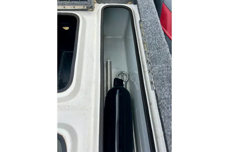 Slide: The Image of Storage compartment of a 1994 Stratos 290 Ski-N-Fish boat, featuring a black fender. - 48