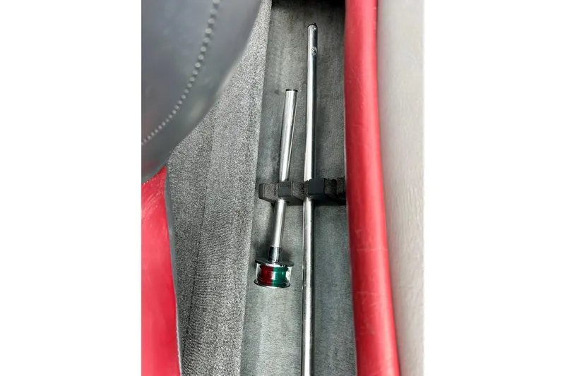 Slide: The Image of Storage compartment in a 1994 Stratos 290 Ski-N-Fish boat with metal rods secured. - 51