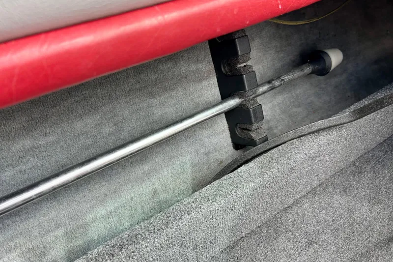 Slide: The Image of Interior of a 1994 Stratos 290 Ski-N-Fish boat showing rod holder and red upholstery. - 52