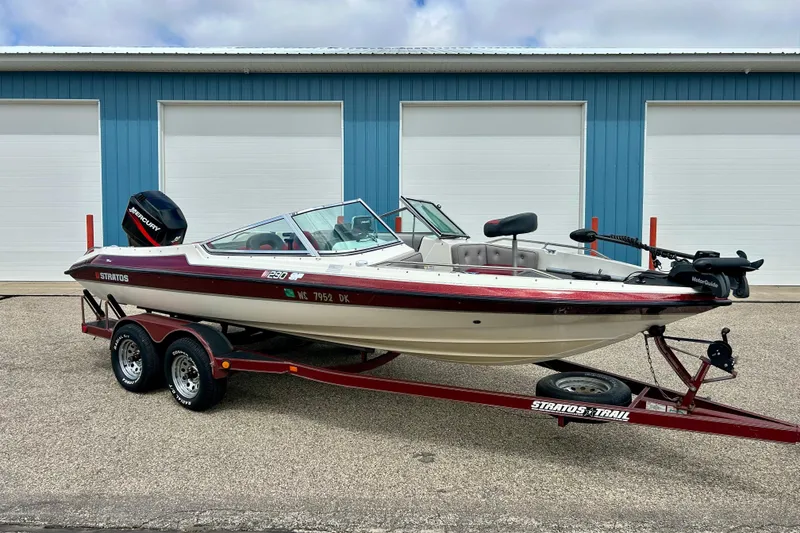 Slide: The Image of 1994 Stratos 290 Ski-N-Fish boat on trailer, parked outside blue building. - 55
