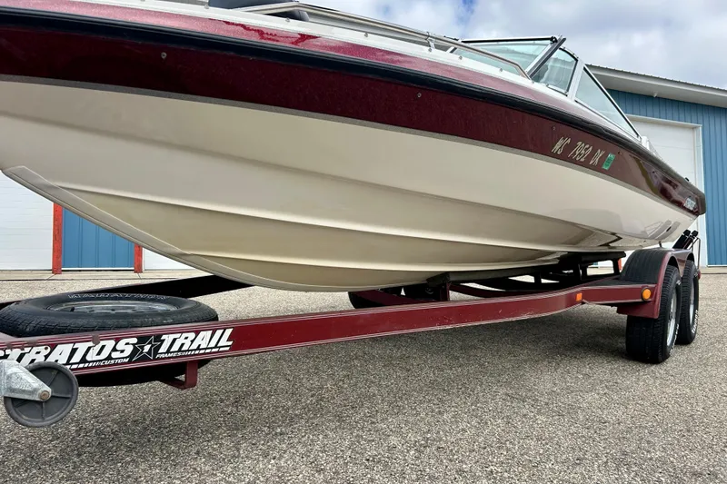 Slide: The Image of 1994 Stratos 290 Ski-N-Fish boat on trailer, red and white hull, outdoor setting. - 9