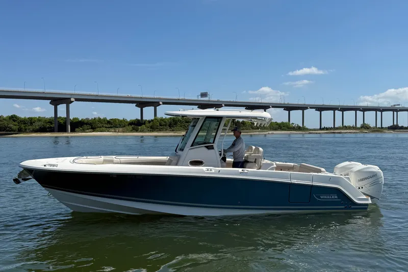 The Image of 2023 Boston Whaler 280 Outrage boat on water near a bridge, clear sky. - 0