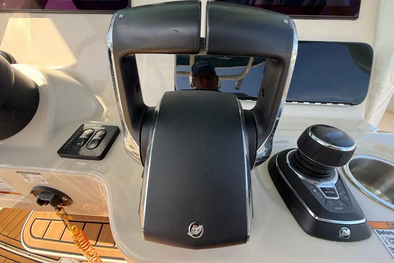 Slide: The Image of Control panel of 2023 Boston Whaler 280 Outrage boat, featuring throttle and joystick. - 17