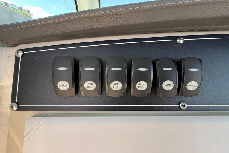 Slide: The Image of Control panel switches on a 2023 Boston Whaler 280 Outrage boat dashboard. - 21