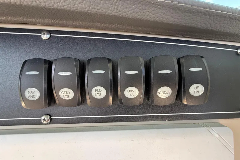 Slide: The Image of Control panel switches on a 2023 Boston Whaler 280 Outrage boat dashboard. - 23