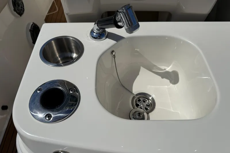 Slide: The Image of Boston Whaler 280 Outrage 2023 boat sink with faucet and cup holders. - 27