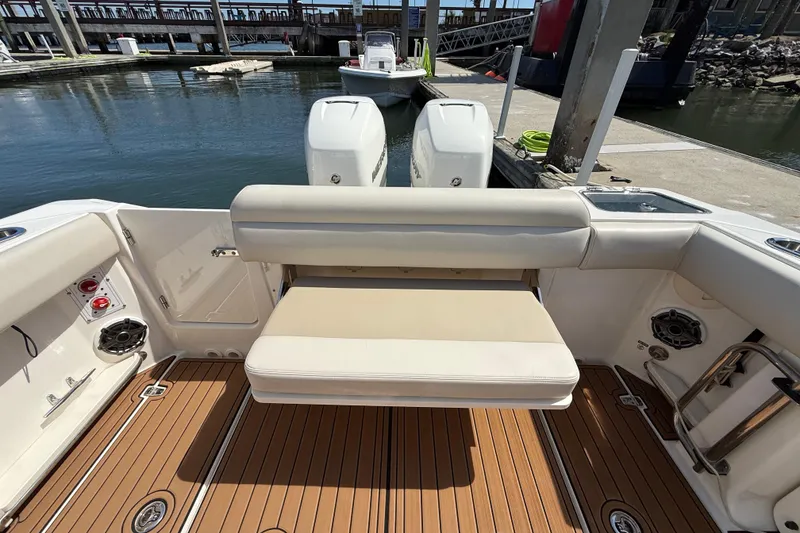Slide: The Image of 2023 Boston Whaler 280 Outrage boat interior with seating and twin engines at dock. - 32