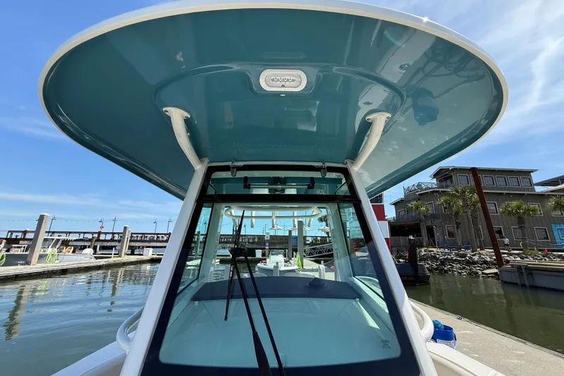 Slide: The Image of Boston Whaler 280 Outrage 2023 boat docked at marina, blue sky background. - 33