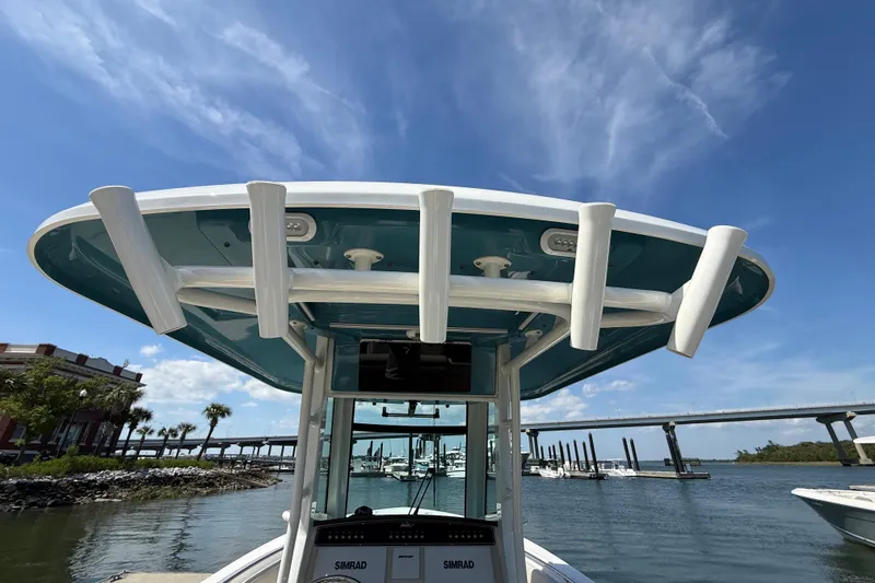 Slide: The Image of 2023 Boston Whaler 280 Outrage boat with rod holders, under a clear blue sky. - 34