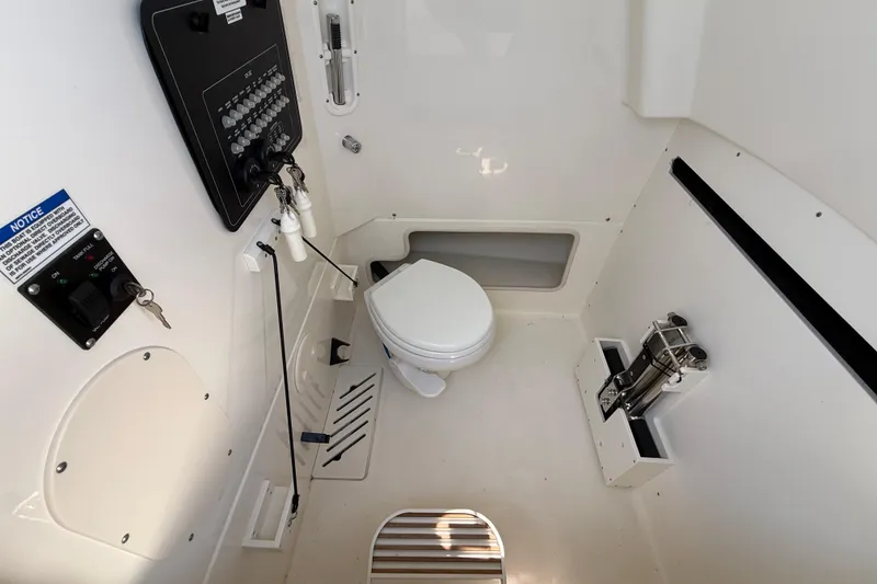 Slide: The Image of Interior of 2023 Boston Whaler 280 Outrage boat featuring a compact marine toilet. - 38