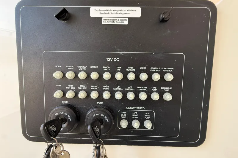 Slide: The Image of Control panel of a 2023 Boston Whaler 280 Outrage boat with labeled switches and keys. - 39