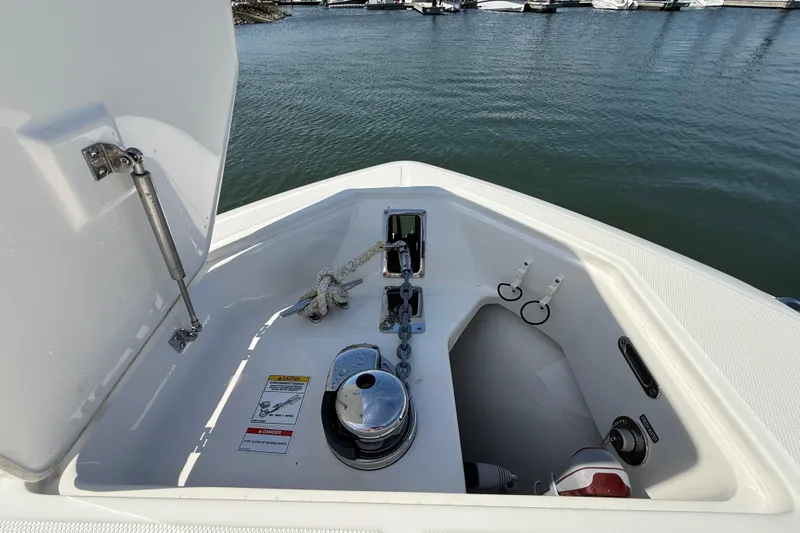 Slide: The Image of Anchor compartment of 2023 Boston Whaler 280 Outrage, featuring marine equipment and open hatch. - 48