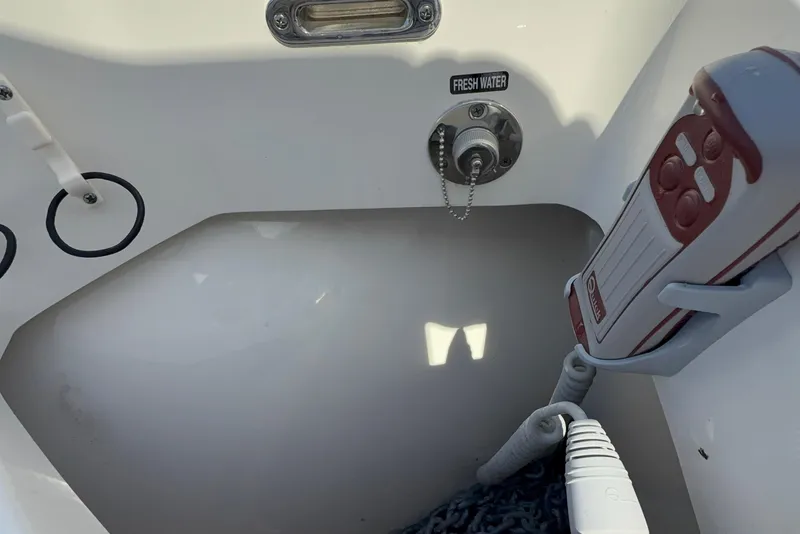 Slide: The Image of Freshwater outlet and coiled hose on 2023 Boston Whaler 280 Outrage boat. - 49