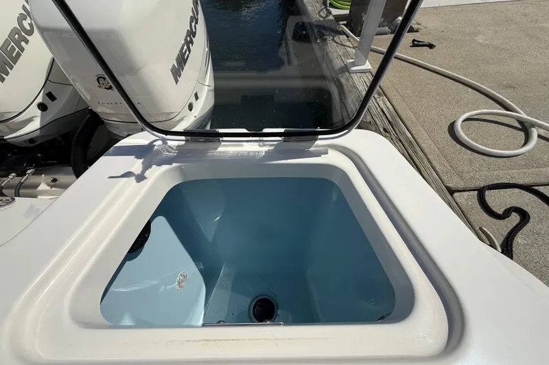 Slide: The Image of Livewell on 2023 Boston Whaler 280 Outrage boat, with Mercury engines in background. - 50