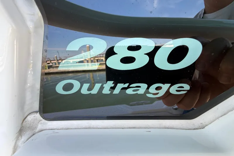 Slide: The Image of Close-up of 2023 Boston Whaler 280 Outrage boat model name on window. - 53