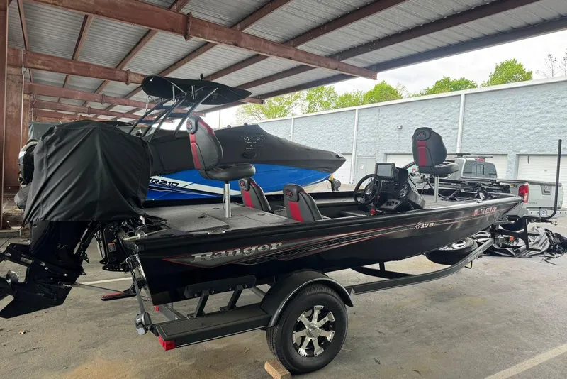 Slide: The Image of 2021 Ranger RT178 boat in storage, featuring sleek black design and modern equipment. - 12