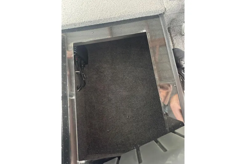 Slide: The Image of Open storage compartment in 2021 Ranger RT178 boat, featuring carpeted interior. - 25