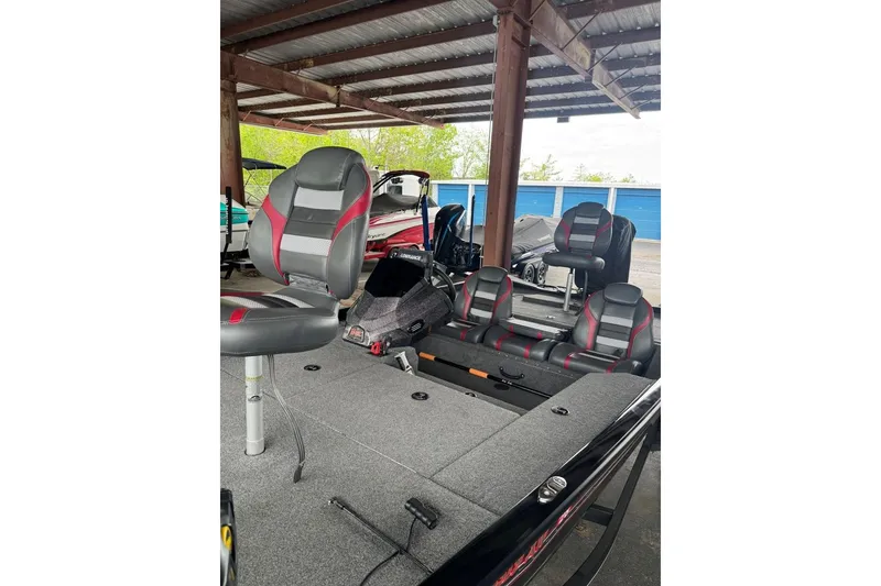 Slide: The Image of 2021 Ranger RT178 boat interior with gray and red seating under a metal roof. - 30