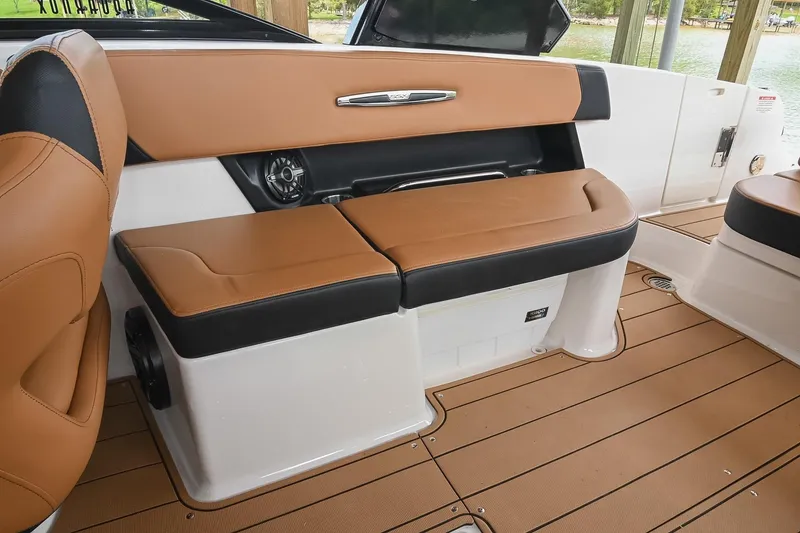 Slide: The Image of 2022 Chaparral 307 SSX boat interior with tan and black seating, elegant design. - 17