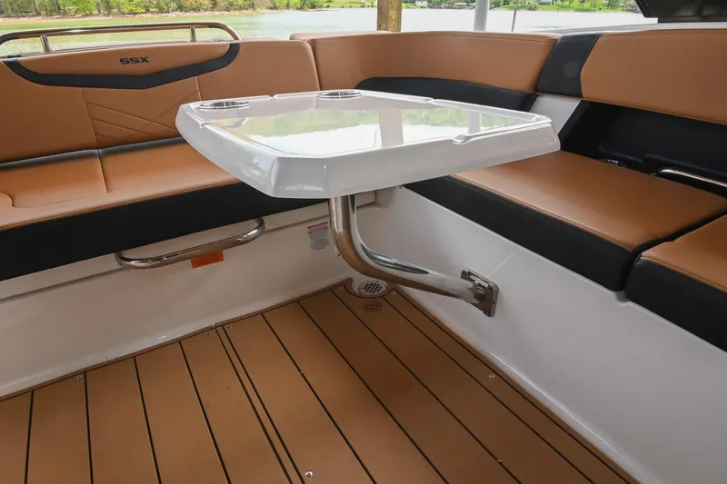 Slide: The Image of 2022 Chaparral 307 SSX boat interior with tan seating and a sleek table. - 21