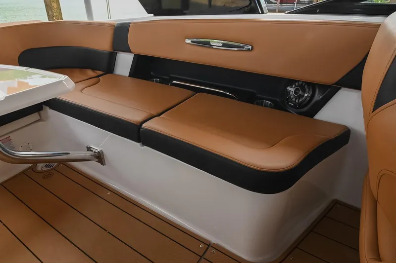 Slide: The Image of 2022 Chaparral 307 SSX boat interior with tan and black seating, sleek design. - 22
