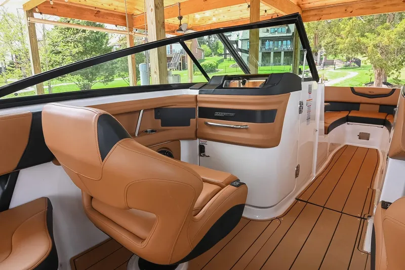 Slide: The Image of 2022 Chaparral 307 SSX boat interior with luxurious tan leather seating and modern dashboard. - 24