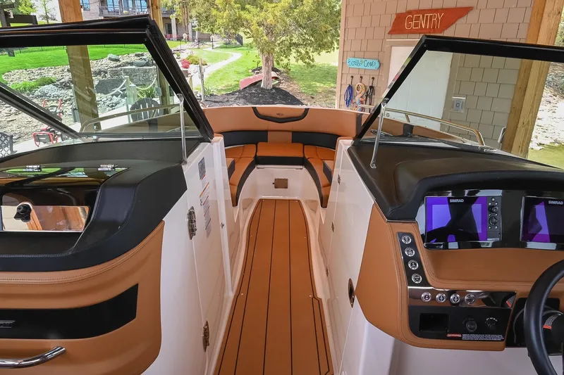 Slide: The Image of 2022 Chaparral 307 SSX boat interior with tan seating and modern dashboard. - 31