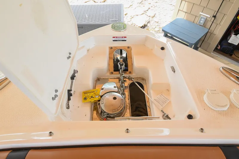 Slide: The Image of Open anchor compartment of 2022 Chaparral 307 SSX boat, showcasing anchor chain and mechanism. - 40