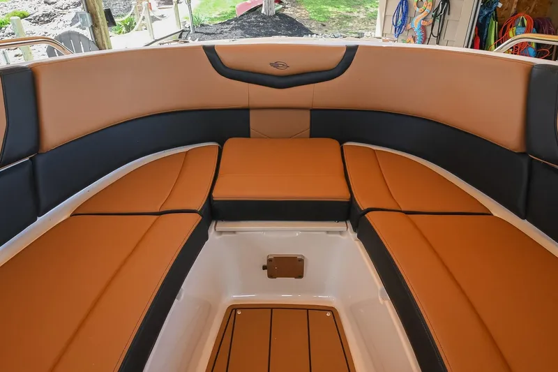 Slide: The Image of 2022 Chaparral 307 SSX boat interior with tan and black seating in a spacious layout. - 46