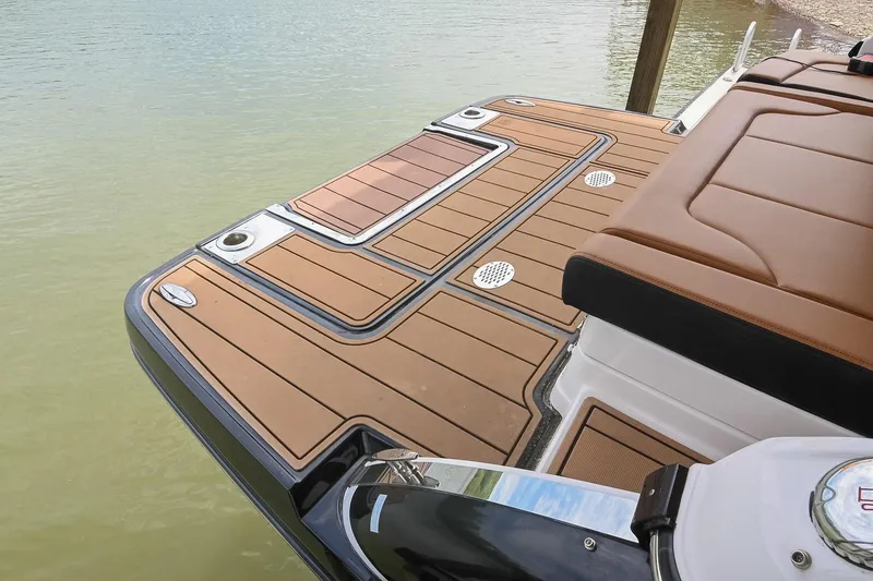 Slide: The Image of 2022 Chaparral 307 SSX boat deck with brown cushioned seating and sleek design. - 8
