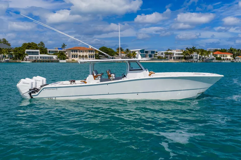 Slide: The Image of 2025 Freeman 43 boat on turquoise water with luxury waterfront homes in the background. - 16