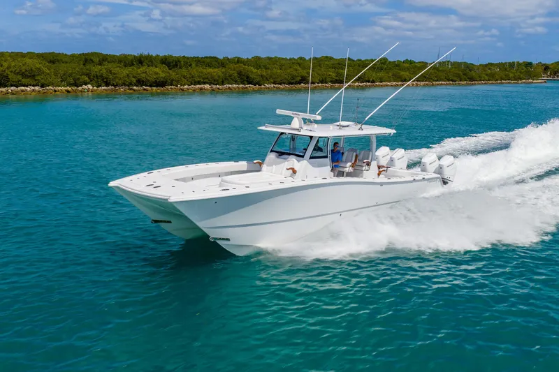 Slide: The Image of 2025 Freeman 43 boat cruising on clear blue water under a sunny sky. - 2