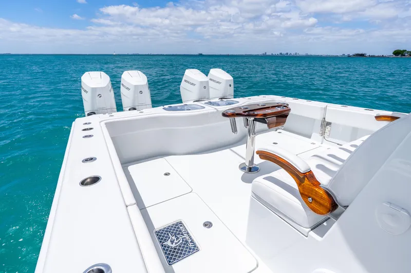 Slide: The Image of Luxury Freeman 43 boat deck with seating, table, and Mercury engines, 2025 model, on open water. - 32