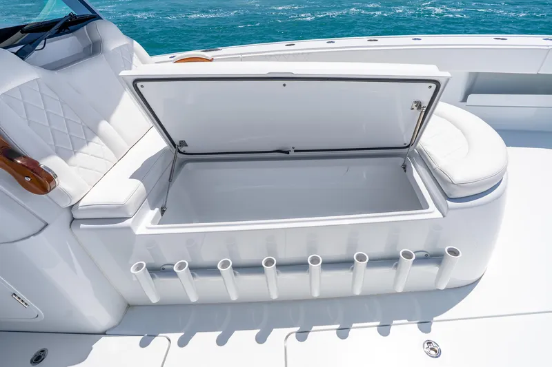Slide: The Image of Open storage compartment on a 2025 Freeman 43 boat with rod holders and cushioned seating. - 45