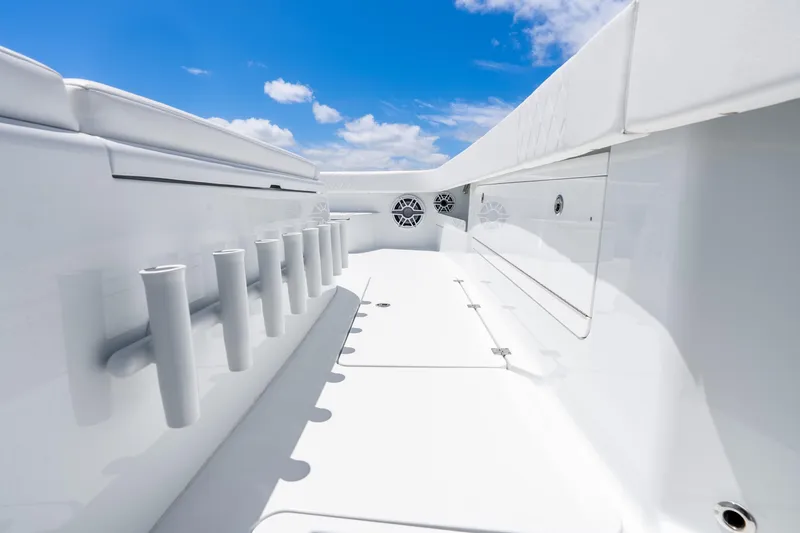 Slide: The Image of 2025 Freeman 43 boat deck with rod holders and storage, under a clear blue sky. - 46