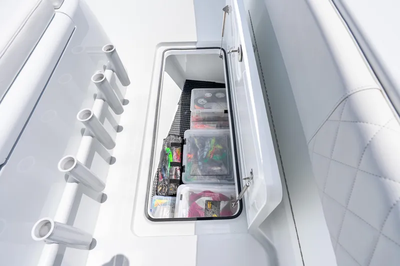 Slide: The Image of Storage compartment on a 2025 Freeman 43 boat, holding organized fishing gear and tackle boxes. - 52