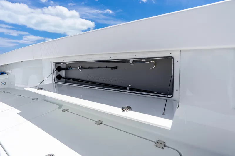 Slide: The Image of Freeman 43 boat storage compartment, showcasing fishing gear under a clear blue sky. - 53