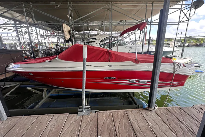The Image of Red 2005 Sea Ray 200 Select boat docked under a covered marina. - 0