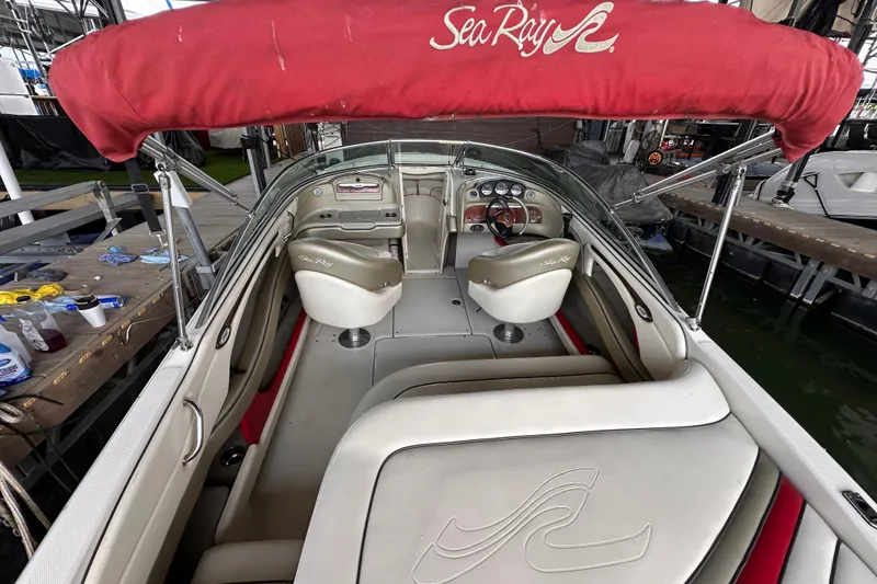 Slide: The Image of 2005 Sea Ray 200 Select boat interior with red canopy and beige seating. - 10