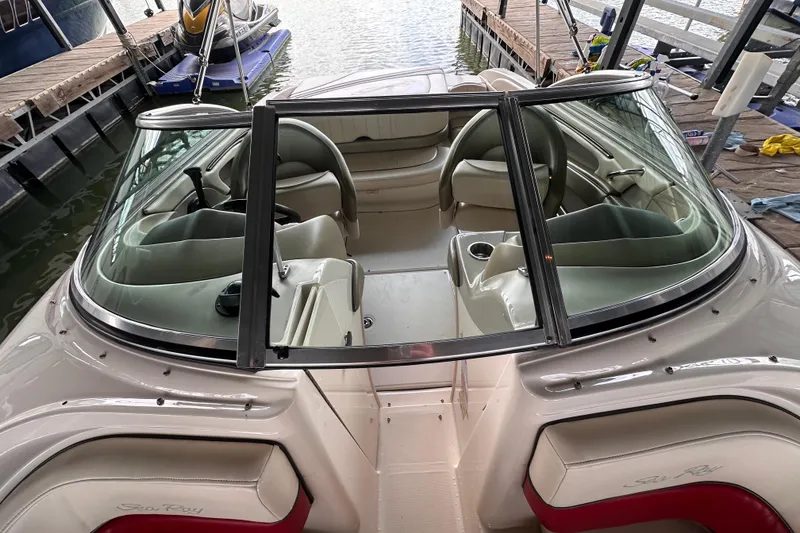 Slide: The Image of 2005 Sea Ray 200 Select boat interior with seating and steering wheel, docked at marina. - 13