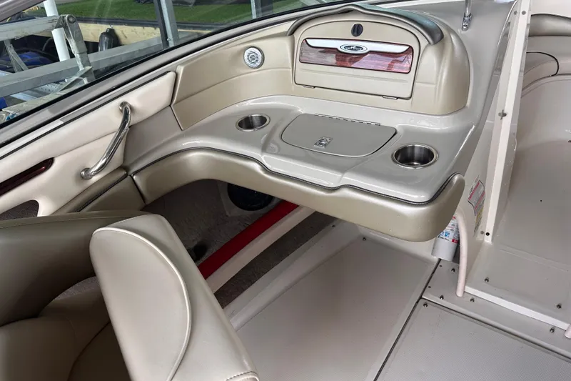 Slide: The Image of Interior of a 2005 Sea Ray 200 Select boat, featuring beige seating and cup holders. - 16