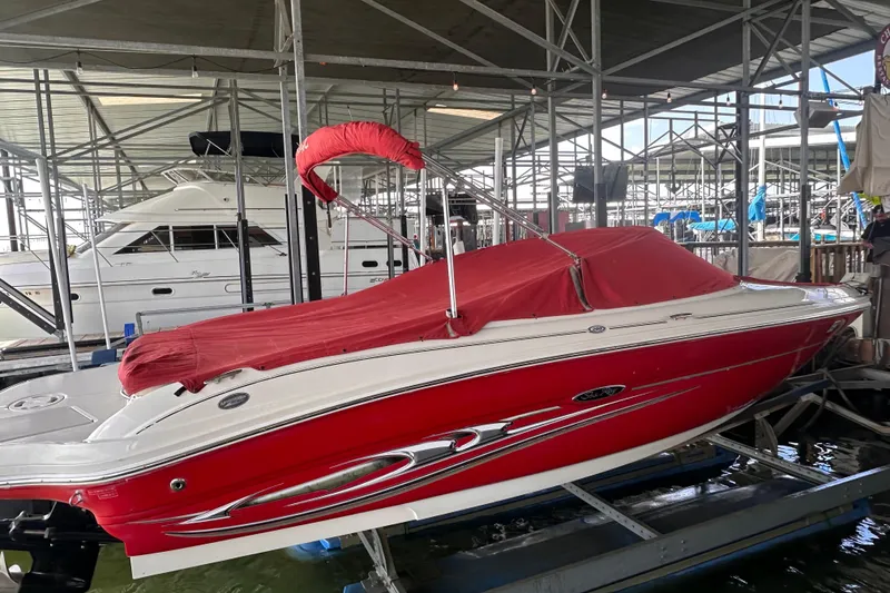 Slide: The Image of 2005 Sea Ray 200 Select boat with red cover in marina storage. - 2
